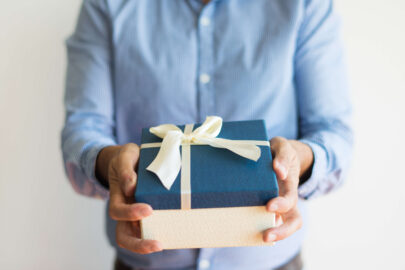 close up unrecognizable man giving gift box camera